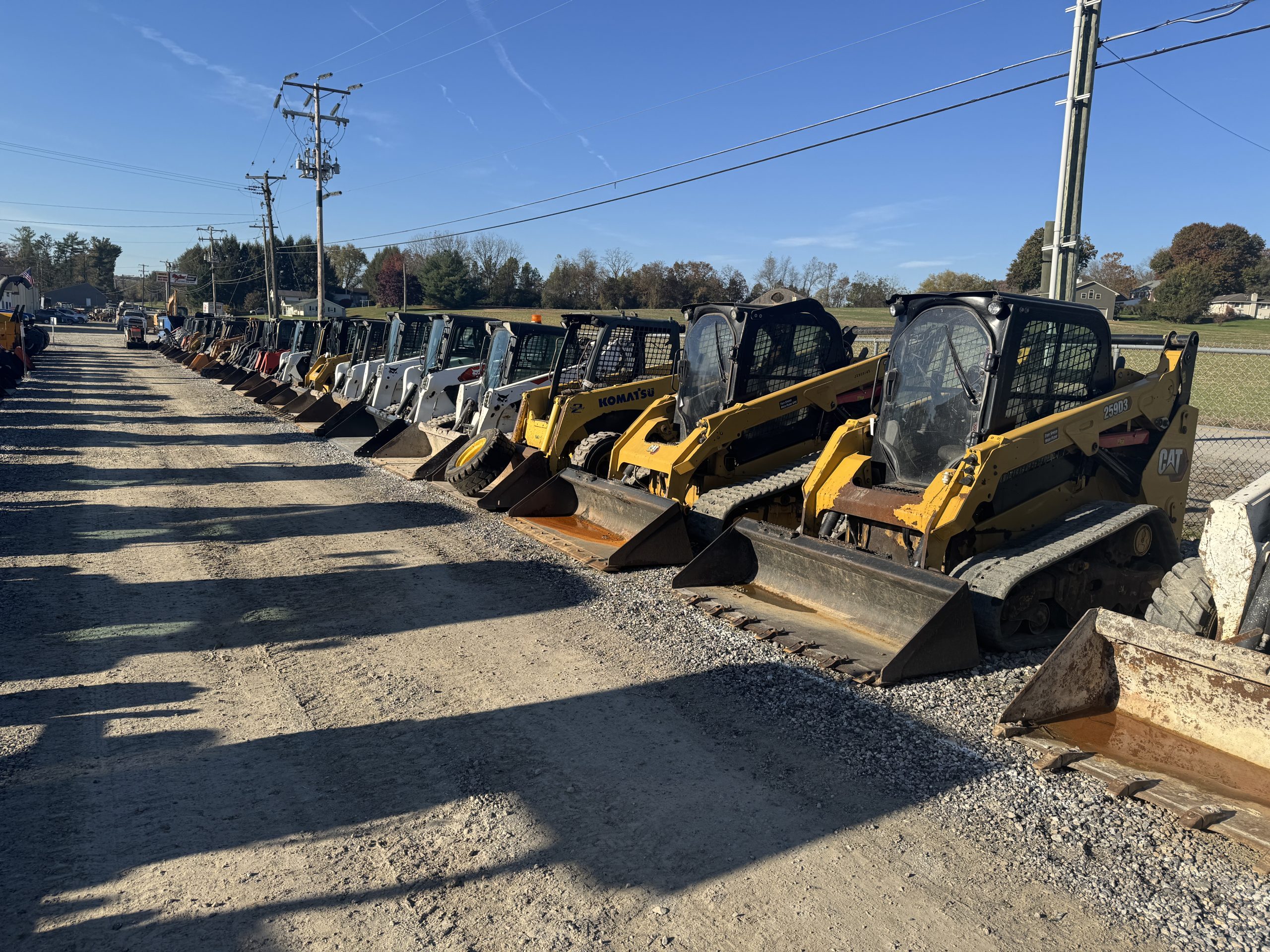 angle view of a row of yellow construction machinery on gravel