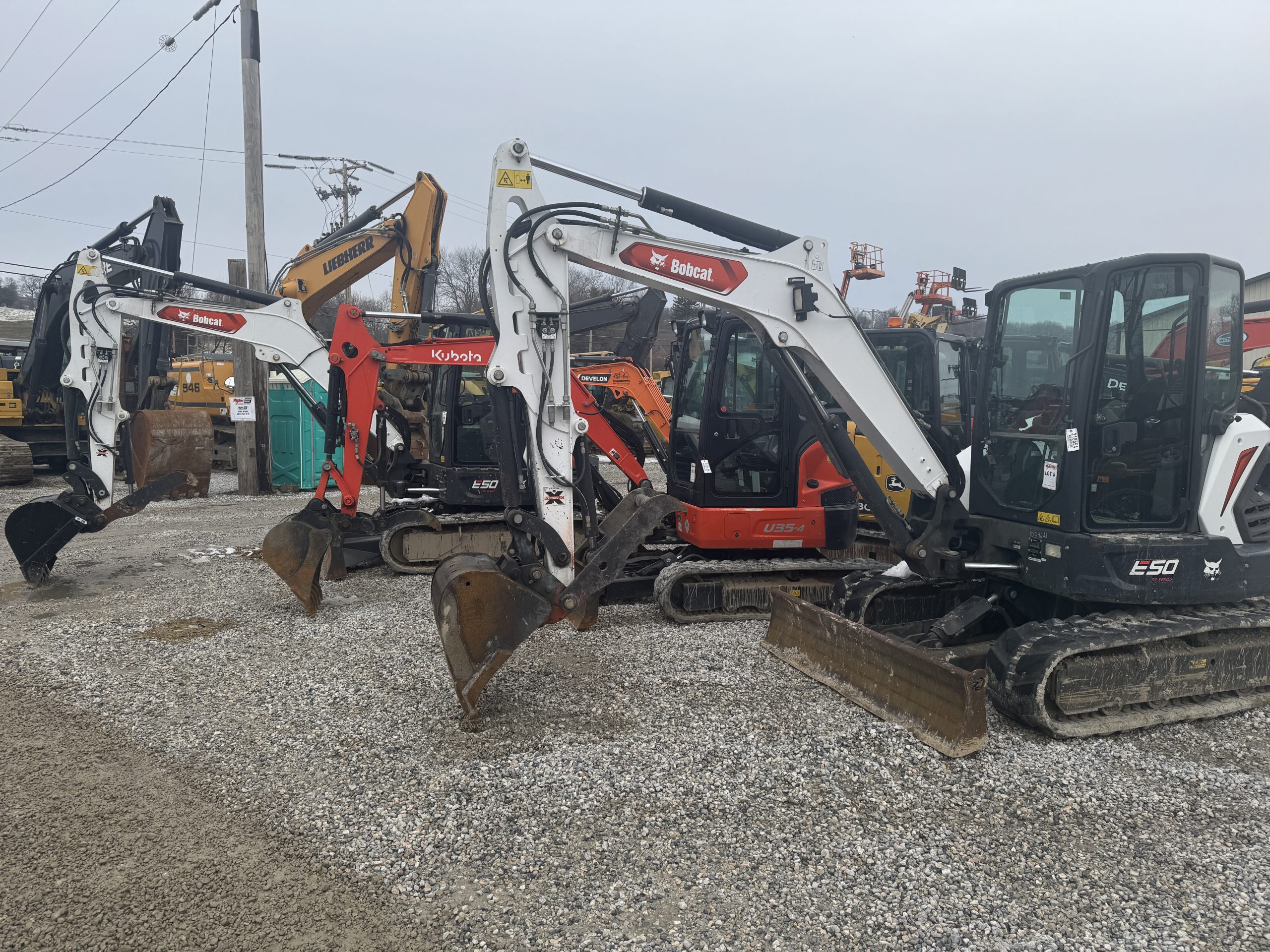 close-up of three skid steer loaders parked side-by-side