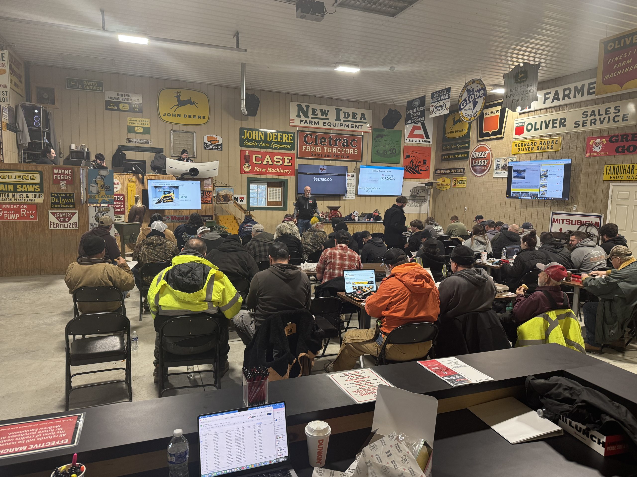 group of people attending an auction with digital monitors