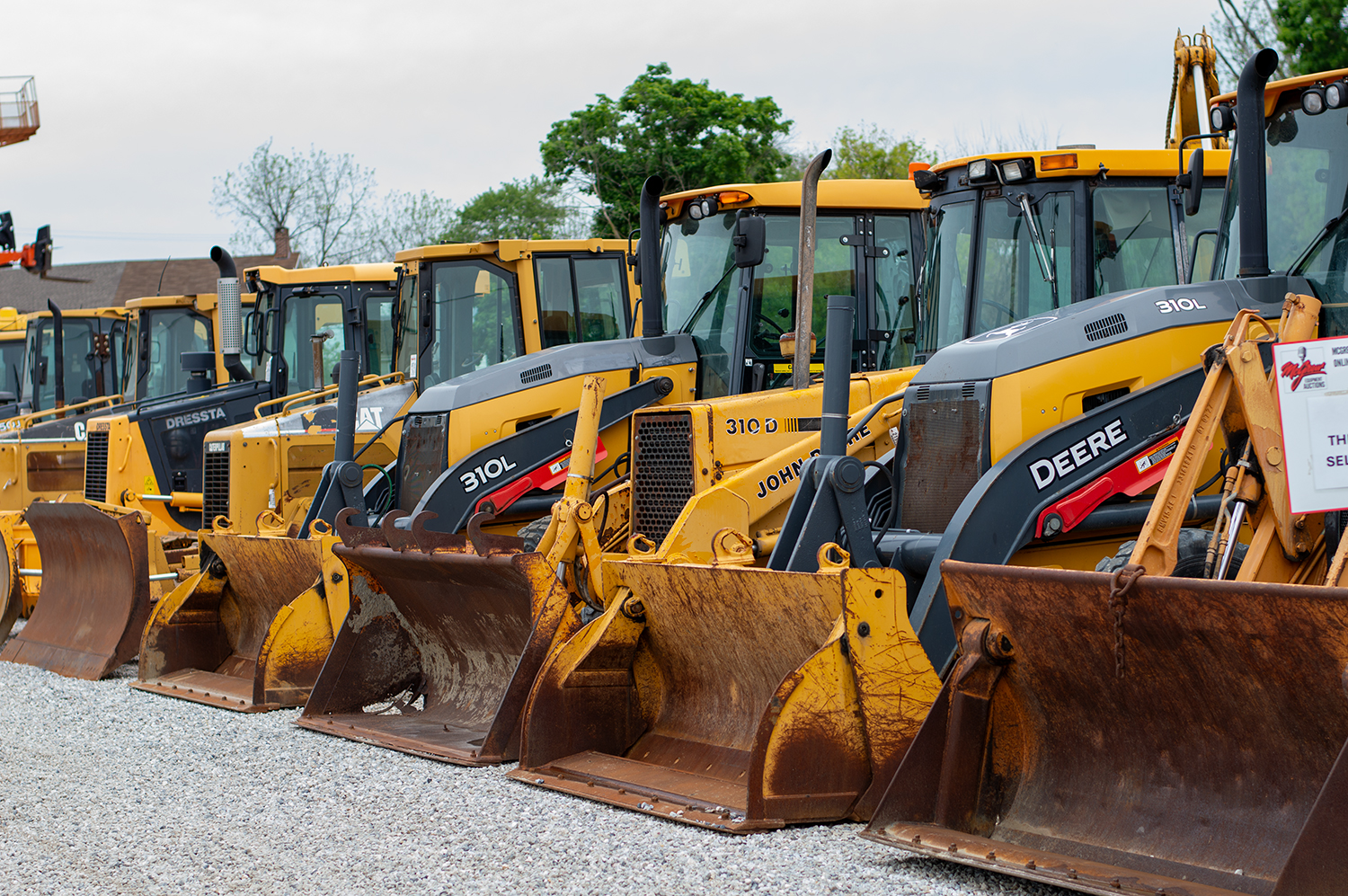 Used Cat and Deere Loaders Lined Up on Auction Lot